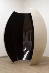 large egglike sculpture with a vertical opening.  white on outside, reflective deep red, almost black on the inside